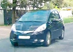 Ein schwarzer Honda Jazz Hybrid im Straßenverkehr. 