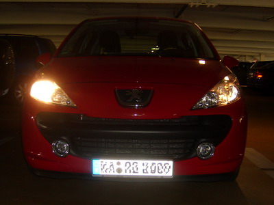 Peugeot 207 mit eingeschalteten Lichtern und defekter Lampe. 