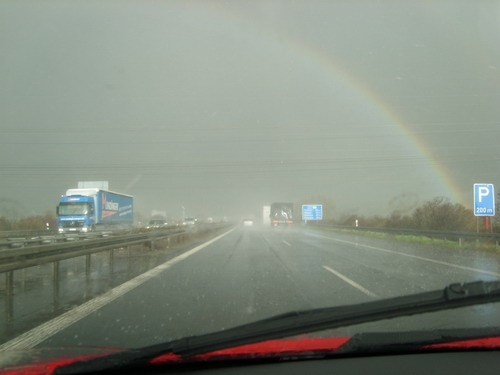 Ein Regenbogen zieht sich über die Fahrbahn. 