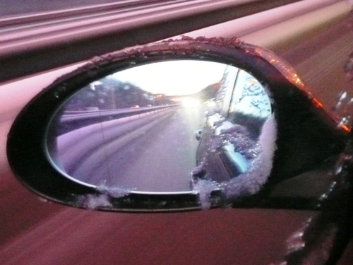 Fahrt über verschneite Autobahnen — ein Blick in den Außenspiegel zeigt, wie kalt es draußen zugeht. 