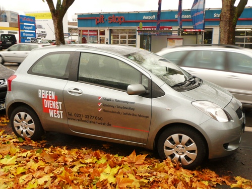 Werkstattersatzfahrzeug Toyota Yaris mit Werbeaufdruck. 