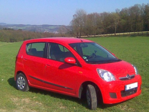 Front und Beifahrerseite eines roten Daihatsu Cuore. 