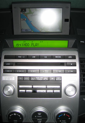 Die silbernen Tasten in der Mitte sind für die Sonderfunktionen der HDD-Musik-Box. Die HDD-Musik-Box im Mazda5 GTA.