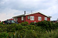 Auto vor dänischem Ferienhaus in der Heide. 