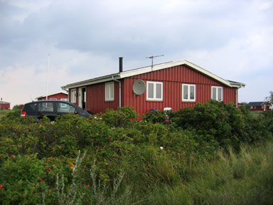 Auto vor dänischem Ferienhaus in der Heide. 