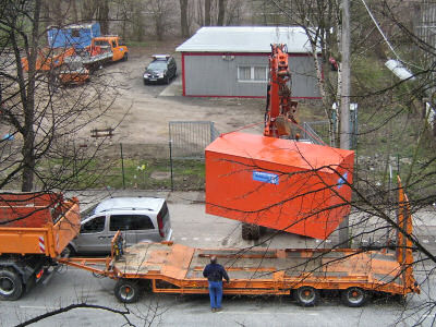 Bagger im Einsatz. Verladung eines Baucontainers.