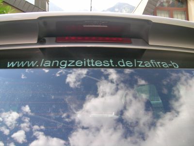 Langzeittest-Schriftzug an der Heckscheibe angebracht. Geschafft! Der Langzeit-Aufkleber ist an der Heckscheibe angebracht.