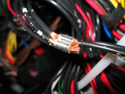 Schwarze Kabel mit Zündstrom hinter dem Sicherungskasten. 