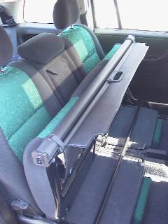 Das Foto zeigt die Rücksitzbank mit senkrechtgestellter Sitzfläche und festgezurrter Laderaumabdeckung. 