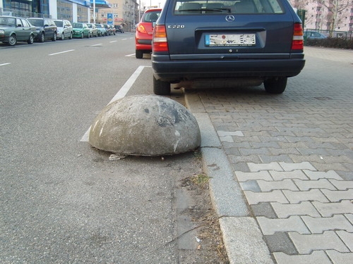 Das Bild zeigt eine Parkplatzbegrenzung aus Beton. 