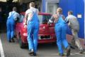 Vier Mitarbeiter schieben den Peugeot 307 von Heinz Höfling in die Werkstatt. 