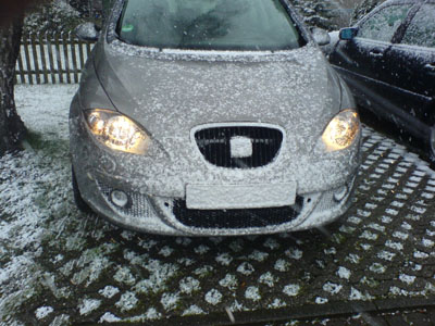 Schnee bedeckt die Motorhaube und das Kennzeichen. 