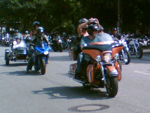 Pärchen auf Harley mit Kamera. Pärchen auf Harley, Frau mit Kamera.
