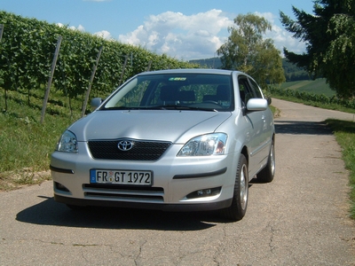 Toyota Corolla vor einem Weinberg. 