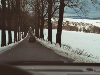 Fahrt mit gebührendem Abstand zu den anderen Teilnehmern, um während der Fahrt auf glatter Straße auch einen Blick auf die Landschaft werfen zu können. Kolonnenfahrt im verschneiten Erzgebirge.