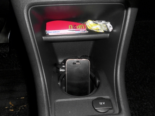 Das Handy steht im Getränkehalter. Handy im Getränkehalter.